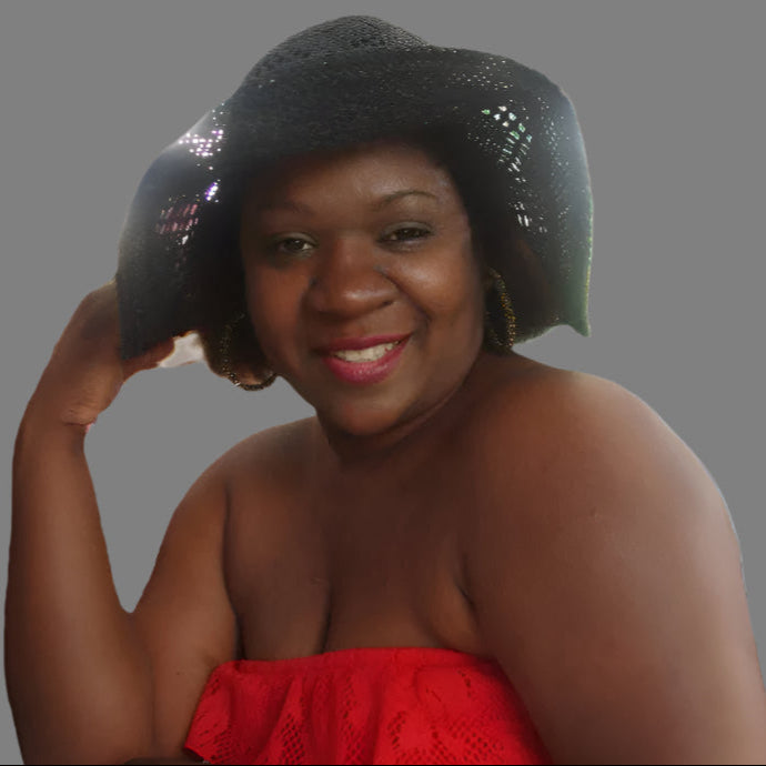 Woman wearing a black textured hat and red dress on a white background